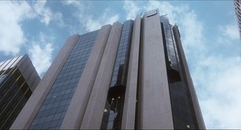 Movie still from “9 to 5” (1980), directed by Colin Higgins – A building with a clock on the side of it; Extreme Wide shot, Low angle