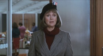 Movie still from “9 to 5” (1980), directed by Colin Higgins – A woman wearing a hat and a jacket; Close Up shot, Over the shoulder angle