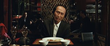 A man sitting at a table with a plate of food in front of him