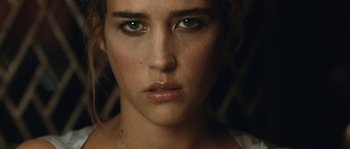 A woman's face in a dimly - lit room