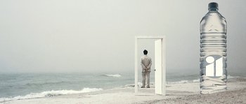 A man standing in front of an open door on the beach