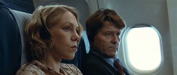 A man and a woman sitting next to each other on a plane