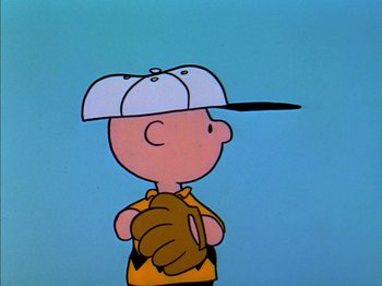 Movie still from “A Boy Named Charlie Brown” (1969), directed by Bill Melendez – A charlie brown character wearing a baseball uniform and a hat; Medium shot, High angle