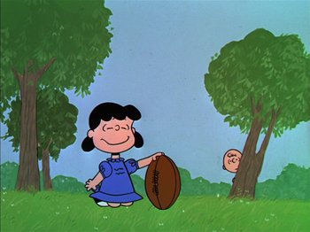 Movie still from “A Boy Named Charlie Brown” (1969), directed by Bill Melendez – A painting of a woman holding a football in a field; Extreme Wide shot, High angle