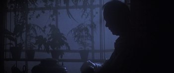 Movie still from “A Bridge Too Far” (1977), directed by Richard Attenborough – A person sitting in front of a window in a dark room; Close Up shot, Low angle