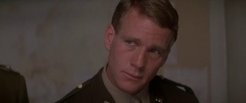 Movie still from “A Bridge Too Far” (1977), directed by Richard Attenborough – A person wearing a military uniform; Close Up shot, Over the shoulder angle