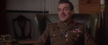 Movie still from “A Bridge Too Far” (1977), directed by Richard Attenborough – A man in a military uniform sitting in a chair; Close Up shot, Low angle