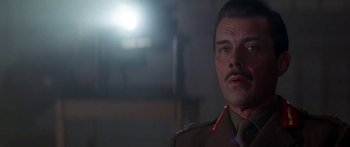 Movie still from “A Bridge Too Far” (1977), directed by Richard Attenborough – A person wearing a military uniform; Close Up shot, Low angle