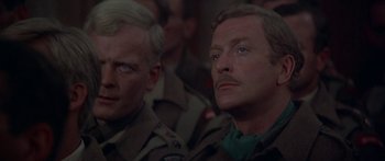 Movie still from “A Bridge Too Far” (1977), directed by Richard Attenborough – Two men in military fatigues looking up at something; Close Up shot, Over the shoulder angle