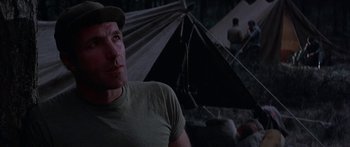 Movie still from “A Bridge Too Far” (1977), directed by Richard Attenborough – A person wearing a hat near some tents; Close Up shot, Low angle