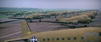 Movie still from “A Bridge Too Far” (1977), directed by Richard Attenborough – A group of airplanes parked on top of a runway; Extreme Wide shot, High angle