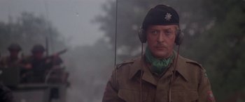 Movie still from “A Bridge Too Far” (1977), directed by Richard Attenborough – A man in a military uniform wearing headphones; Close Up shot, Low angle