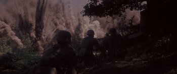 Movie still from “A Bridge Too Far” (1977), directed by Richard Attenborough – A group of men in military uniforms standing in front of a cloud of smoke; Wide shot, Low angle