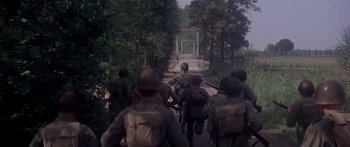 Movie still from “A Bridge Too Far” (1977), directed by Richard Attenborough – A group of soldiers walking down a road; Wide shot, High angle