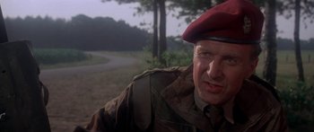 Movie still from “A Bridge Too Far” (1977), directed by Richard Attenborough – An older man wearing a military uniform and a red beret; Close Up shot, Low angle