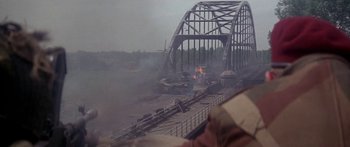 Movie still from “A Bridge Too Far” (1977), directed by Richard Attenborough – An image of a bridge that has been burned down; Close Up shot, Over the shoulder angle