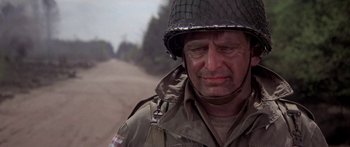 Movie still from “A Bridge Too Far” (1977), directed by Richard Attenborough – An older man in a military uniform and helmet; Close Up shot, Over the shoulder angle