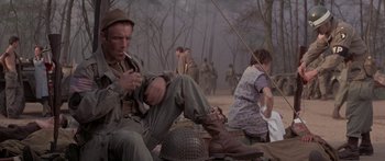 Movie still from “A Bridge Too Far” (1977), directed by Richard Attenborough – A group of people sitting on the ground in the woods; Medium shot, Low angle