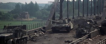 Movie still from “A Bridge Too Far” (1977), directed by Richard Attenborough – A tank is parked on the side of a bridge; Wide shot, High angle