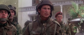 Movie still from “A Bridge Too Far” (1977), directed by Richard Attenborough – A man in a military uniform wearing a helmet; Close Up shot, Over the shoulder angle