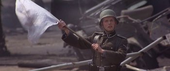 Movie still from “A Bridge Too Far” (1977), directed by Richard Attenborough – A man in a military uniform holding an axe; Medium shot, Low angle