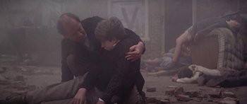 Movie still from “A Bridge Too Far” (1977), directed by Richard Attenborough – A man and a boy are hugging in the middle of a room; Medium shot, High angle