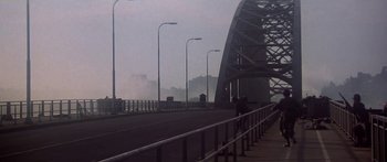 Movie still from “A Bridge Too Far” (1977), directed by Richard Attenborough – A view of a bridge from across the street; Extreme Wide shot, Low angle