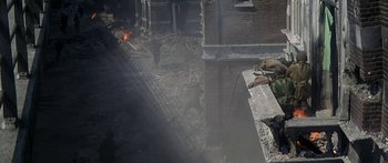 Movie still from “A Bridge Too Far” (1977), directed by Richard Attenborough – A man standing on top of a brick building; Wide shot, High angle