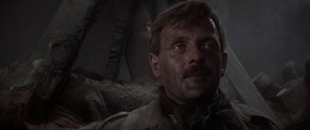 Movie still from “A Bridge Too Far” (1977), directed by Richard Attenborough – A person wearing a suit and tie; Close Up shot, Low angle