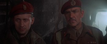 Movie still from “A Bridge Too Far” (1977), directed by Richard Attenborough – Two men in military uniforms are standing next to each other; Close Up shot, Low angle