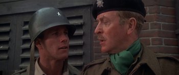 Movie still from “A Bridge Too Far” (1977), directed by Richard Attenborough – Two men in military uniforms talking to each other; Close Up shot, Over the shoulder angle