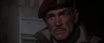 Movie still from “A Bridge Too Far” (1977), directed by Richard Attenborough – A person wearing a military uniform; Close Up shot, Low angle