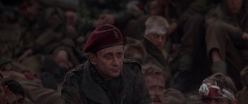 Movie still from “A Bridge Too Far” (1977), directed by Richard Attenborough – A man in a red hat and a crowd of people; Close Up shot, High angle