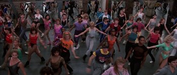 Movie still from “A Chorus Line” (1985), directed by Richard Attenborough – A large group of people are dancing in a gym; Wide shot, High angle
