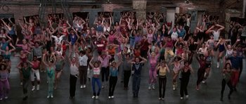Movie still from “A Chorus Line” (1985), directed by Richard Attenborough – A large group of people are doing a dance move; Wide shot, High angle
