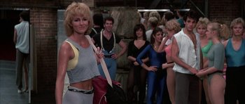 Movie still from “A Chorus Line” (1985), directed by Richard Attenborough – A group of people standing in a room; Medium shot, Over the shoulder angle