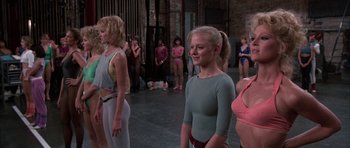 Movie still from “A Chorus Line” (1985), directed by Richard Attenborough – A group of women standing next to each other in a room; Medium shot, Over the shoulder angle