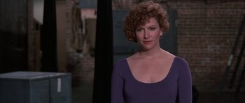 Movie still from “A Chorus Line” (1985), directed by Richard Attenborough – A person with curly hair wearing a purple shirt; Medium shot, Over the shoulder angle
