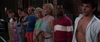 Movie still from “A Chorus Line” (1985), directed by Richard Attenborough – A group of people standing next to each other; Medium shot, Low angle