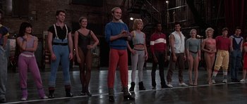 Movie still from “A Chorus Line” (1985), directed by Richard Attenborough – A group of people standing on a dance floor; Wide shot, Low angle