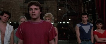 Movie still from “A Chorus Line” (1985), directed by Richard Attenborough – A man and a woman standing next to each other in front of a fire escape; Close Up shot, Low angle