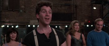 Movie still from “A Chorus Line” (1985), directed by Richard Attenborough – A man and a woman standing next to each other in front of a brick wall; Close Up shot, Low angle