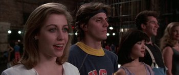 Movie still from “A Chorus Line” (1985), directed by Richard Attenborough – A man and a woman standing next to each other in front of lights; Close Up shot, Low angle
