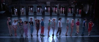 Movie still from “A Chorus Line” (1985), directed by Richard Attenborough – A group of women standing in a line in front of a mirror; Wide shot, High angle