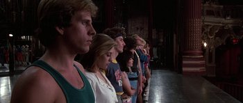 Movie still from “A Chorus Line” (1985), directed by Richard Attenborough – A group of people standing in a row on a stage; Medium shot, Low angle