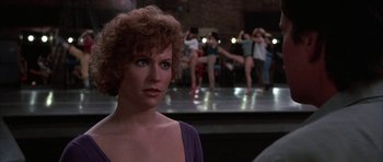 Movie still from “A Chorus Line” (1985), directed by Richard Attenborough – A person in front of a group of people; Close Up shot, Over the shoulder angle