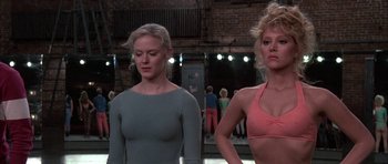Movie still from “A Chorus Line” (1985), directed by Richard Attenborough – A couple of women standing next to each other; Medium shot, Low angle
