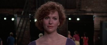 Movie still from “A Chorus Line” (1985), directed by Richard Attenborough – A person with curly red hair; Close Up shot, Over the shoulder angle