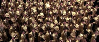 Movie still from “A Chorus Line” (1985), directed by Richard Attenborough – A large group of people in gold suits and hats; Extreme Wide shot, Overhead angle