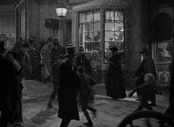 Movie still from “A Christmas Carol” (1938), directed by Edwin L. Marin – A black and white photo of people walking in the snow; Extreme Wide shot, High angle